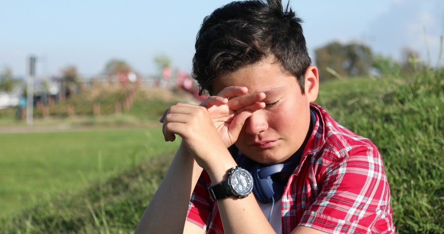 Sad preteen boy crying at the park alone Royalty-Free Stock Footage #1030380890
