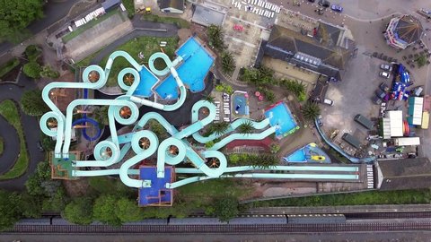 Aerial drone view looking straight down from above colorful summer time fun at water park near a beach