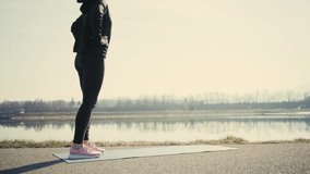 Young woman doing sports workout. 4K slow motion video. Woman running walking in outdoors park on sunny day, close-up legs sport shoes. Female exercising in the gym