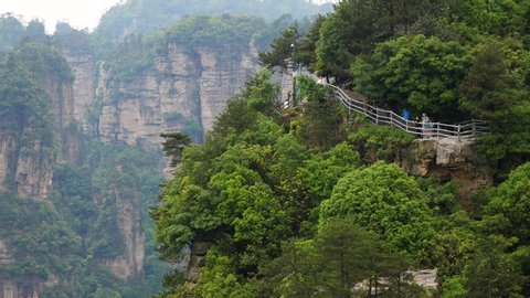 Zhangjiajie, CHINA - 08 May 2019: Many tourists walking on the hiking trails looking the amazing views from the observation point and breathtaking views from the heights of mountains rock formations