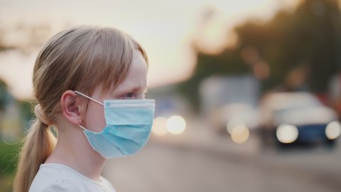 A child in a protective gauze bandage stands near a dusty highway. Health and ecology problems