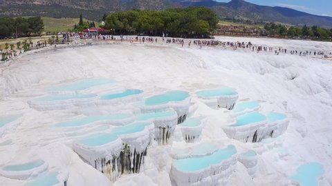 Tilt shift of camera from travertines to tourists in Pamukkale, Turkey. Aerial footage 4k