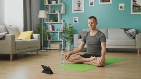 Man drinking water from a bottle during yoga classes online