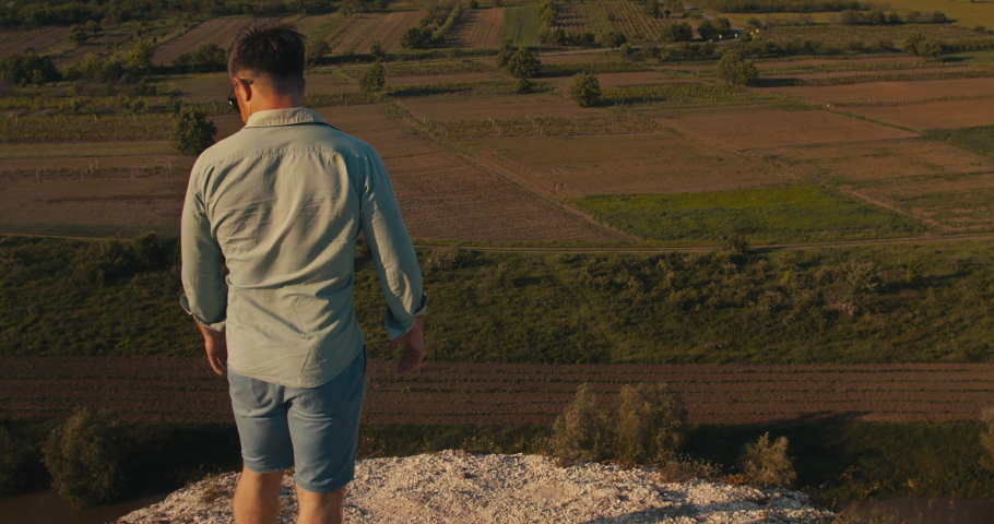 Young male standing on a cliff enjoying the view.