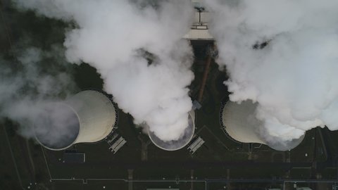 Overhead aerial view of cooling towers of lignite (brown coal) fired power station billowing smoke in Germany
