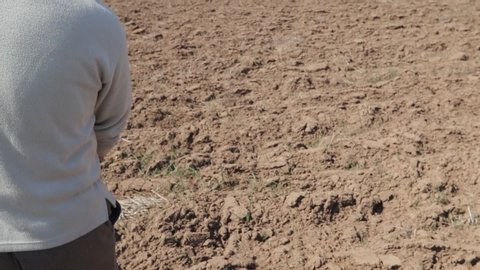 Slow motion footage of a person sowing wheat on a field