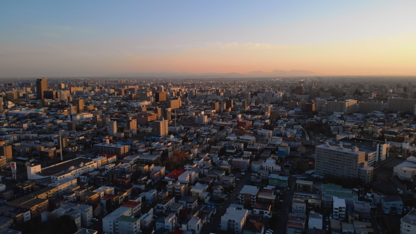 First rays of sunlight hitting Sapporo city - Aerial descending and left diagonal flight, Hokkaid?, Japan | Shutterstock HD Video #1030411310