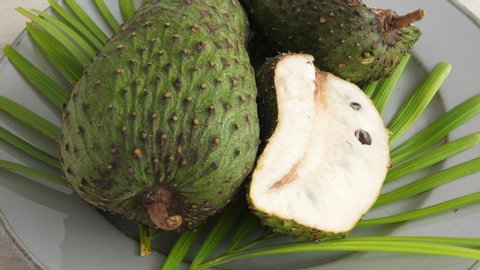 One soursop graviola, exotic, tropical fruit Guanabana on plate, Rotating