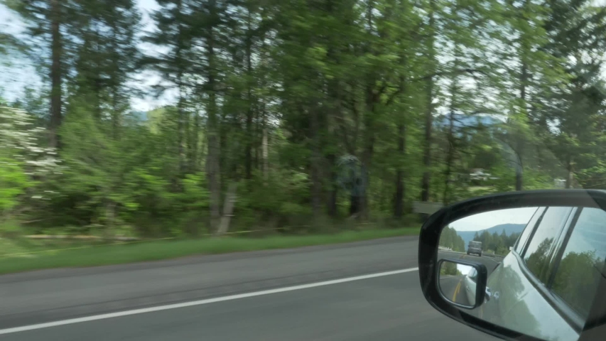 Driving watching rearview mirror followed by car truck suspense