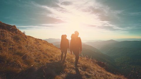 The couple walking in mountains against the sunset background. slow motion