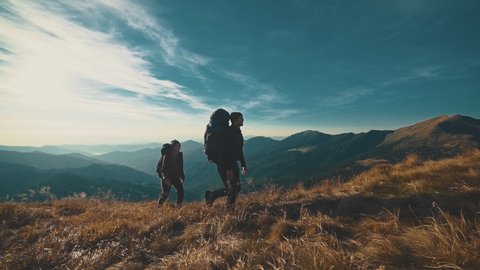 The couple walking on the mountain on a sunny background. slow motion
