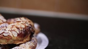 SLOW MOTION Shot of beautiful almond croissants in a plate being powdered with white sugar IN REVERSE - 1080p Slide shot from Left to Right at 120fps - Powered by Shutterstock - Get 15% off with code: PIKWIZARD15
