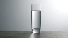 Aspirin tablet slowly drops into a glass of water. Full HD video. Slow motion