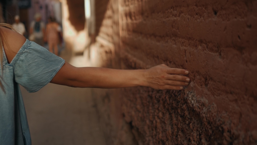 Close up women hand touches a white concrete wall with sunshine, shade and shadow in the morning. Marrakech morocco traditional market medina Royalty-Free Stock Footage #1030422074