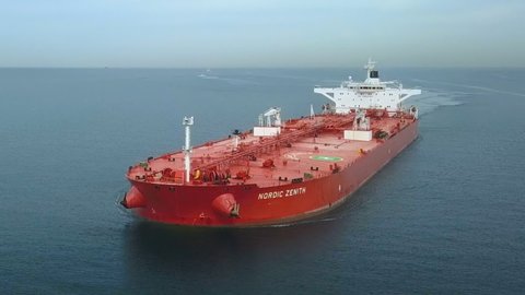 ISTANBUL - CIRCA 2019: Aerial view of the bow and front deck of a red tanker ship on ride. Supertanker Nordic Zenith loaded with full of oil underway in the open sea. Crude oil tanker ploughs through 