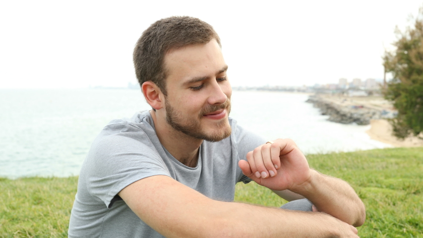 Happy husband looking at wedding ring sitting on the grass