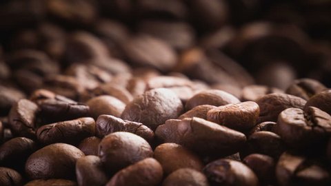 A pile of roasted coffee beans rotating. Close up