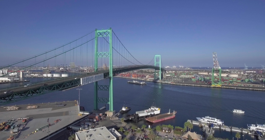 Aerial, drone shot, of the Vincent Thomas Bridge, traffic on seaside freeway 47 and towards the Terminal island, on a sunny day, at Long Beach, in San Pedro, Los Angeles, California