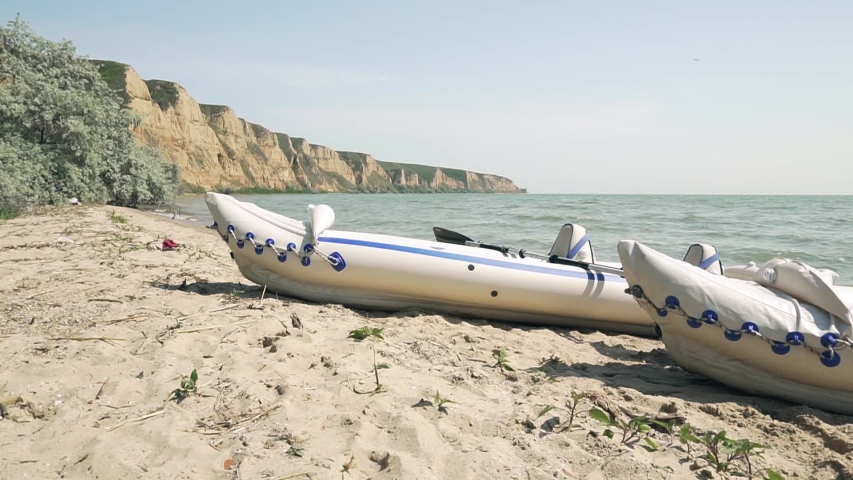 two inflatable boats stand on the beach near river 
