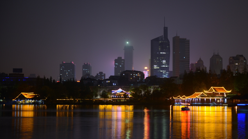 Time Lapse Nanjing Skyline with Office Tower and People Ride Boat on Lake Night