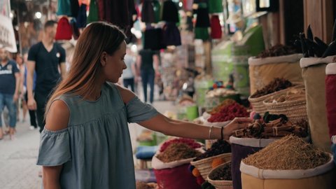 Woman walking on MAROCCAN MARRAKECH spices market. Woman walking on beautiful african arabian spices market and choose spices, travel tourist