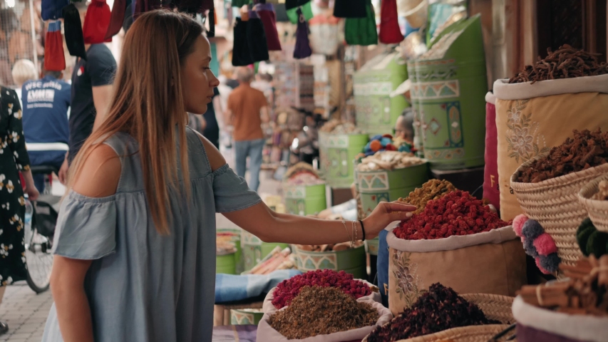 Woman walking on MAROCCAN MARRAKECH spices market. Woman walking on beautiful african arabian spices market and choose spices, travel tourist | Shutterstock HD Video #1030470494