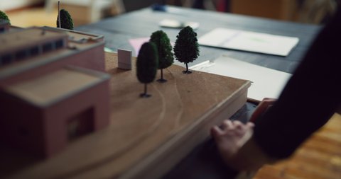 Business and design thinking, craftsperson conceptualizing. A female architect working on a scale model in a modern, industrial office. Shot on 4k RED camera. 