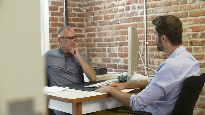 Older businessman interviewing younger male candidate for job and reviewing resume.Shot on Sony FS700 in PAL format at a frame rate of 25fps Royalty-Free Stock Footage #10304711