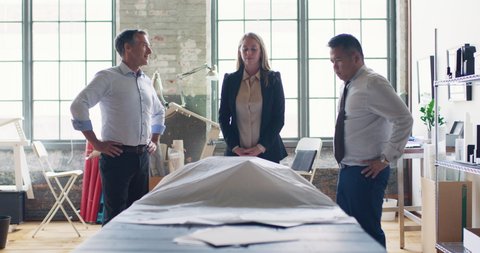 In modern, industrial office, architect reveals her scale model to her coworkers and they collaborate on urban planning project. Business and design thinking and collaboration. Shot on 4k RED camera.