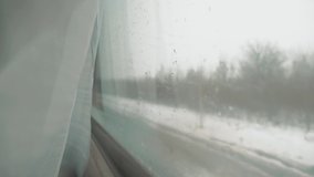rain snow on glass window. railway concept train journey lifestyle travel . view beautiful from the window of a moving train railway trip Russia winter. slow motion video. interior inside train