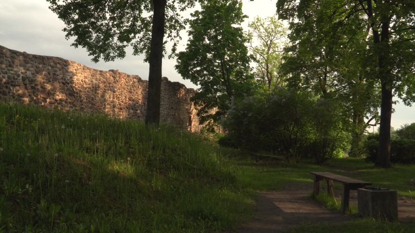 Trees on the hill of the castle ruins. Park landscape of medieval palace place in Latvia, the town of Dobele.