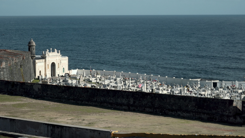 The Puerto Rican flag proudly waves in a cemetery in Viejo San Juan, Puerto Rico, by the ocean on a moody day.