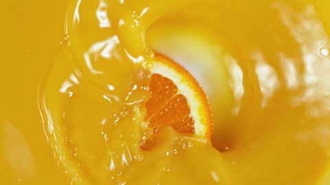 Super Slow Motion Shot of Orange Slice Splashing to Orange Juice at 1000fps.