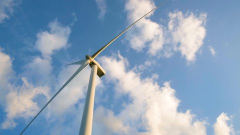 View up, bottom view of wind turbine, windmill isolated on blue sky background. Royalty high-quality free stock video footage looking up wind turbine, windmill energy converter in blue sky background