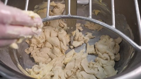 Dough mixing in a professional kneader machine in kitchen of bakery or at the manufacturing. Stock footage. Dough making in slow motion