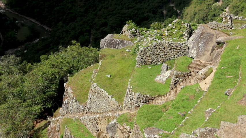 Close-up high angle still shot of a steep slope with stone staircases and terraces overlooking the Sacred Valley, Machu Picchu, Peru