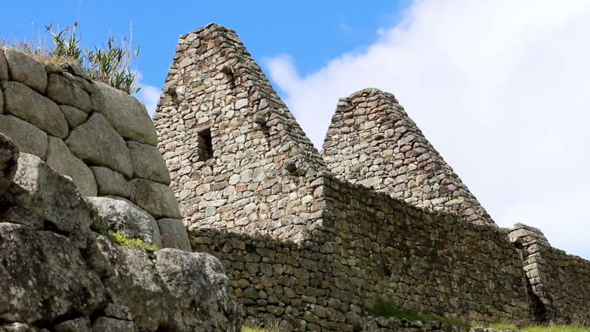 Close-up low angle side-view still shot of triangular constructed ancient stones and megalith wall, Machu Picchu Ruins, Peru