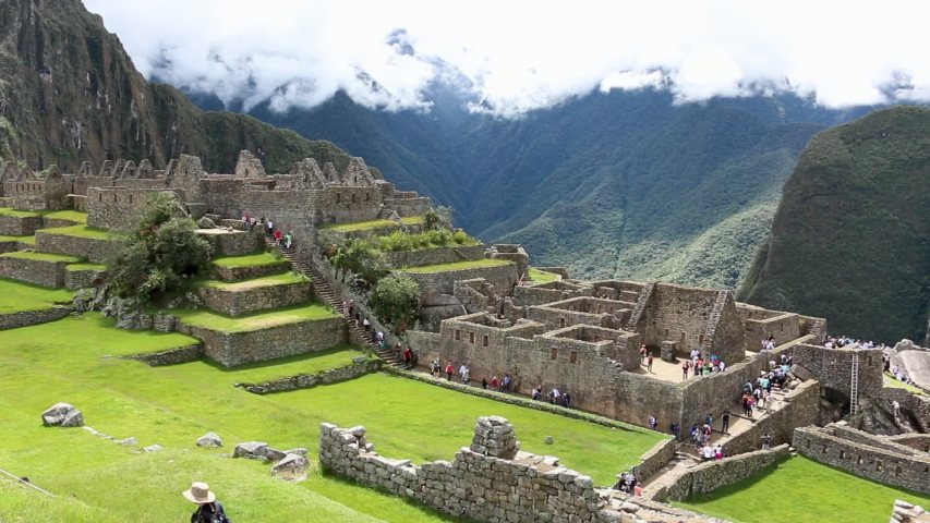 Still shot overlooking tourists walking around the abandoned and ancient incan structures on Machu Picchu