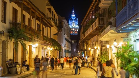 Cartagena de Indias, Colombia - December 10: Night time lapse view of tourists on the streets of the Walled City showing architectural landmark Cartagena Cathedral in Cartagena, Colombia.