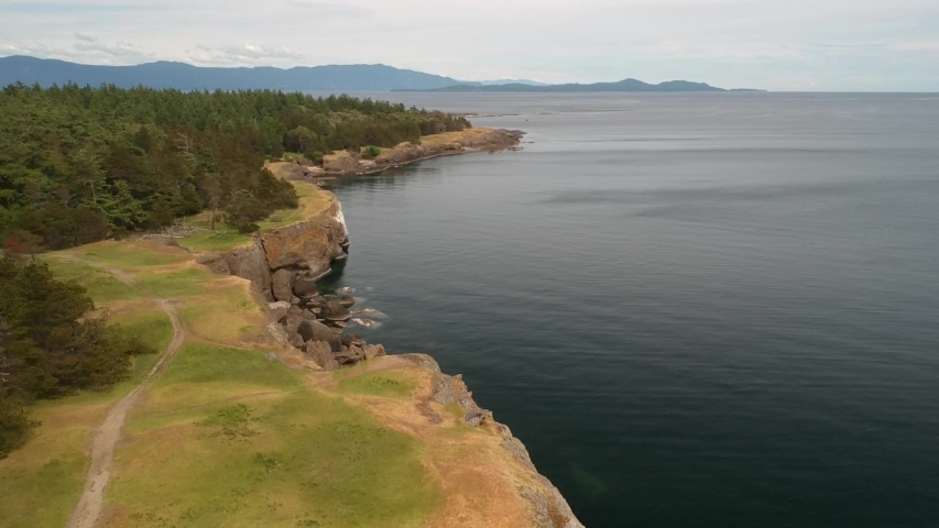 Drone shot of Bluffs with ocean views and green grass