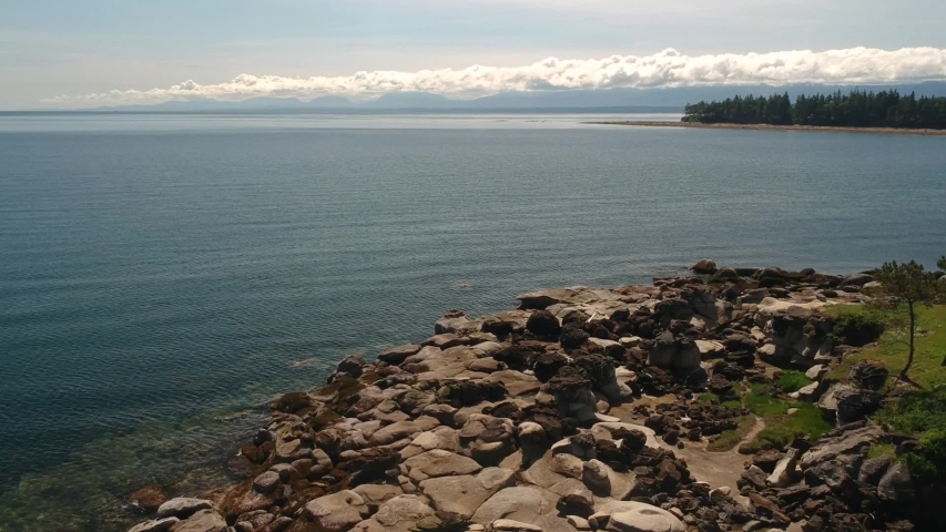 drone shot of tribune bay rock formations with eagle fly by