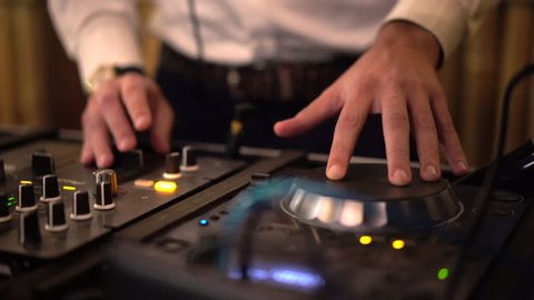 DJ entertaining people at the party and working on professional cd usb player in disco club Stock Video