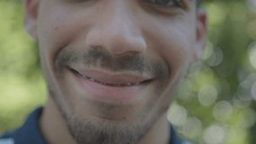 Close up shot of smiling young Caucasian mans mouth with brackets. Lifestyle concept