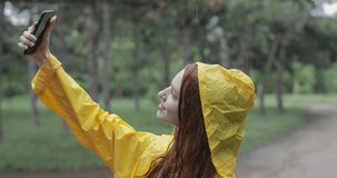 A young girl shoots herself on the camera phone while in the rain forest. in slow motion. Shot on Canon 1DX mark2 4K camera