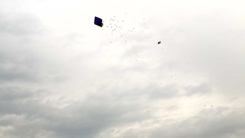 A bird group flying with Kites in the cloudy sky, The traditional hand made kites in Pakistan and India