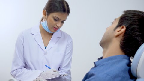 Stock video of a beautiful young doctor speaking to the patient at her clinic - Dentist in India. Healthcare and Medical Concept