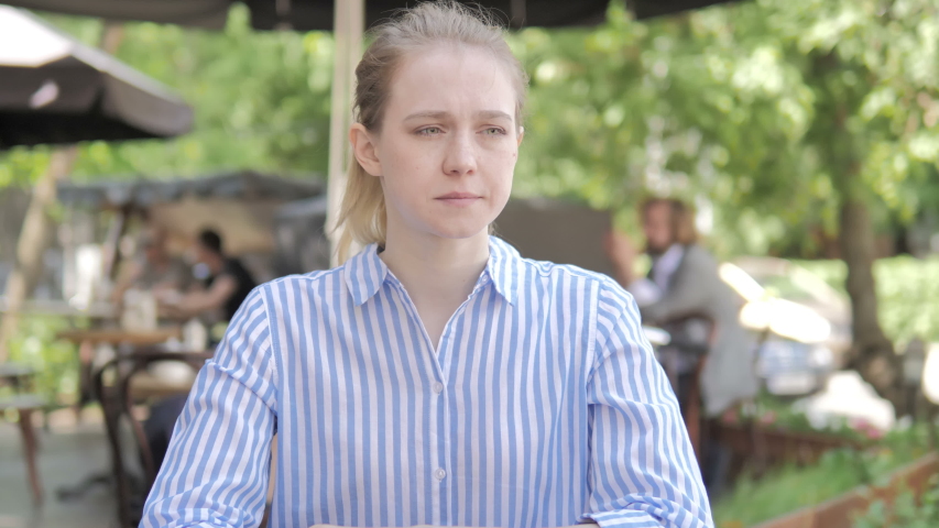 Tense Young Woman with Headache Sitting in Cafe Terrace
