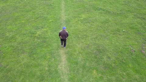 Zavaliv, Ukraine - April 21, 2019: Aerial view of a man walking in green field.