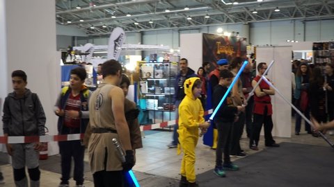 Rome, 7 April 2019: Boys dressed as cosplay simulate fighting with luminous toy lightsabers at Romics 2019