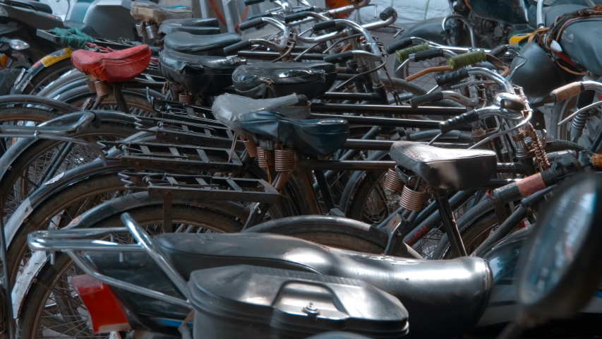 Many old fashioned bicycles stand on the street Delhi, India. Shot in motion